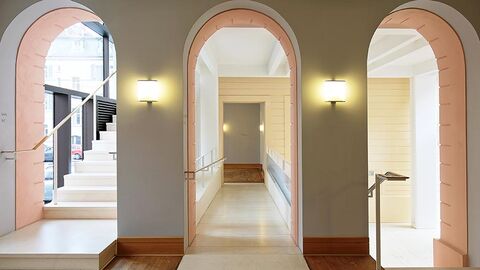 Eingangsbereich des Staatsgerichtshofs mit Blick auf drei Türbögen, hinter denen sich eine Treppe aufwärts, ein Flur und eine Treppe abwärts befinden.