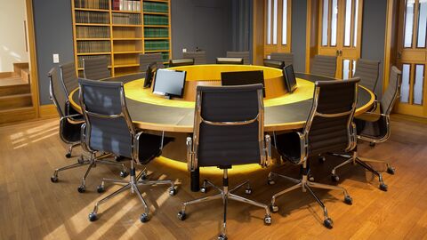 Besprechungsraum mit rundem Tisch und Stühlen.